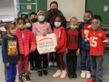 Group photo of students and their teacher at George Melcher Elementary School during their Read for 15 pizza party. Two students hold a pizza box.