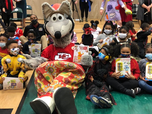 KC Wolf sits on the floor surrounded by students and their books during the Read for 15 kickoff event.